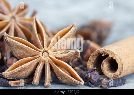 Anise star, cinnamon sticks, and cloves on old grey wood closeup Stock Photo