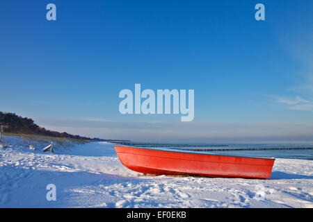 Red boat on shore of the Baltic Sea in winter Stock Photo