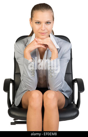 Businesswoman on office chair, with head reclined upon her hands Stock Photo