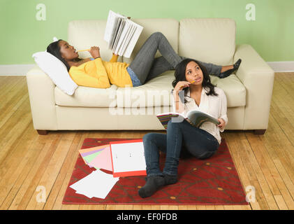 Students doing homework in living room Stock Photo