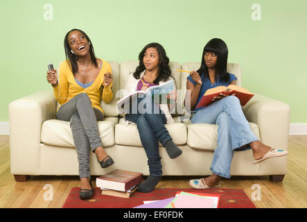 Students doing homework in living room Stock Photo