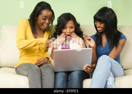 Three friends looking at laptop Stock Photo