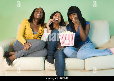 Three friends eating popcorn Stock Photo