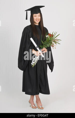 Young woman wearing a graduation cap and gown Stock Photo