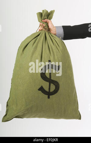 An arm holding a bag of money Stock Photo