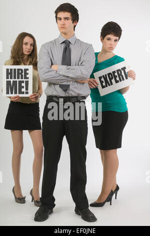 Two women holding signs beside a businessman Stock Photo