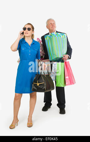 Man holding woman's shopping bags Stock Photo