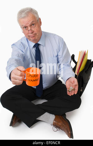 Businessman panhandling for spare change Stock Photo