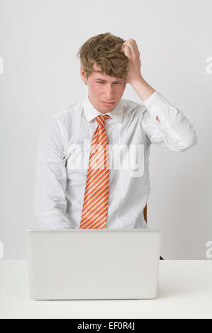 Frustrated man working on laptop Stock Photo