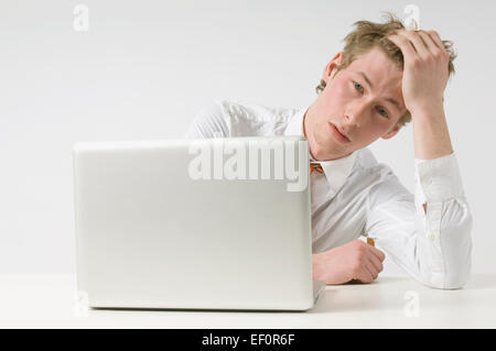 Tired man looking at laptop Stock Photo