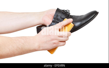 Shoeshiner brushing black shoe by brush isolated on white background Stock Photo