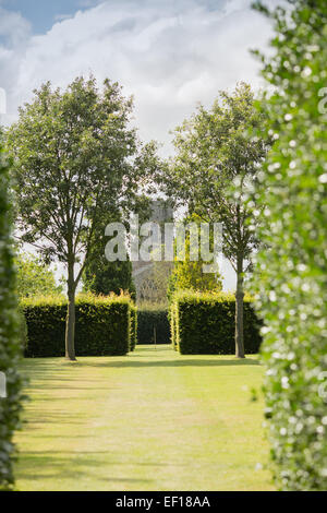 East Ruston church seen through a gap in the trees at East Ruston Old Vicarage Gardens, Norfolk Stock Photo