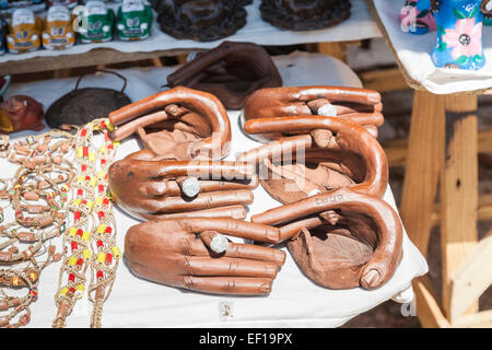 Unusual tourist souvenirs: carved wooden ashtrays in the shape of hands holding Cuban cigars displayed for sale in a local shop, Trinidad, Cuba Stock Photo