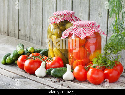 canned tomatoes and pickled cucumbers, homemade preserved vegetables Stock Photo