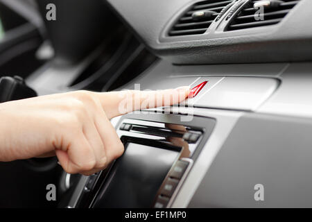 hand pressing Car emergency lights button on dashboard Stock Photo