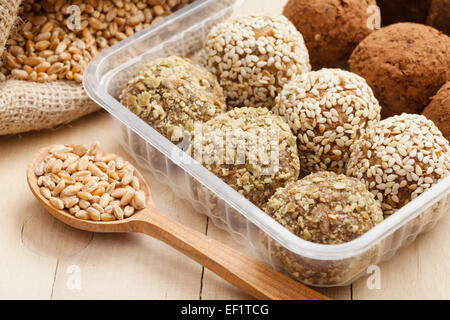 macrobiotic healthy food: balls from ground wheat sprouts with sesame, pumpkin seeds and chocolate sprinkles in plastic box; Stock Photo