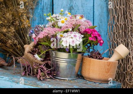garden flowers in bucket and mortar with healing herbs Stock Photo