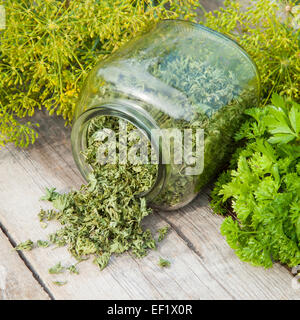 Fresh and dried chopped parsley leaves on wooden plank Stock Photo