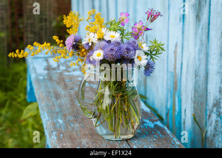 bouquet of garden flowers and healing herbs on old wooden bench Stock Photo