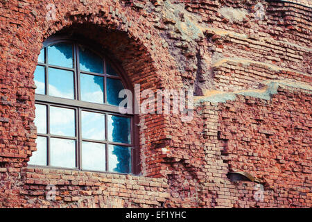 arched window in a aged red brick wall Stock Photo