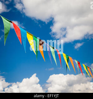multi colored bunting triangular flags hanging on blue sky background Stock Photo