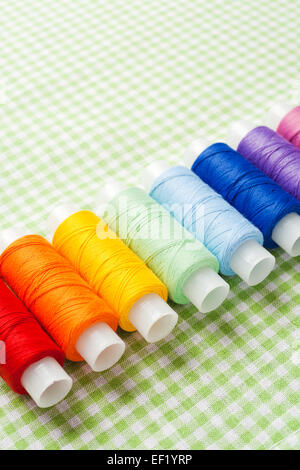 row of thread spools in rainbow colors, skein collection, top view Stock Photo