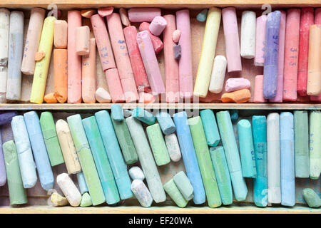 Pastel crayons in wooden artistic box closeup, top view. Stock Photo