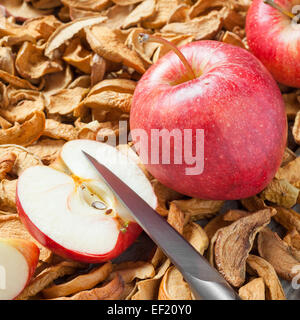 dried apple slices, knife and red fresh red apple fruit close up Stock Photo