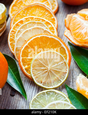 Dried orange and lemon slices, ripe tangerines on old wooden table. Stock Photo