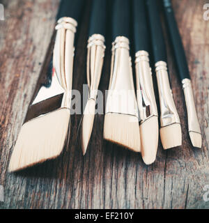 Set of artist paintbrushes closeup on old rustic wooden table.