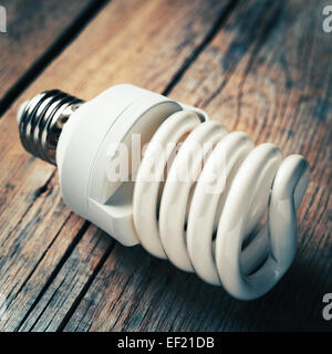 Close up of energy saving light bulb on wooden background. Vintage stylized. Stock Photo