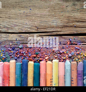 Artistic pastel crayons and pigment dust on old rustic wooden background. Stock Photo