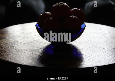 Oranges in a blue bowl displayed on a chess board Stock Photo