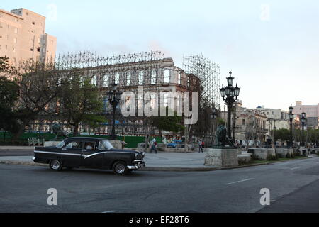 Building being renovated and old American car passing by, Old Havana, Cuba Stock Photo