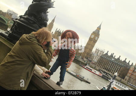 London, UK. 25th January, 2015. A man takes a photos of a Chuky looking doll on the south bank of the river Thames. Credit:  david mbiyu/Alamy Live News Stock Photo