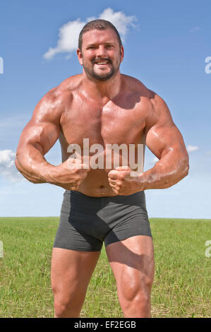Bodybuilder outdoors flexing Stock Photo