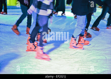 Blurred lower body shoot of ice skaters on out door ice rink Stock Photo