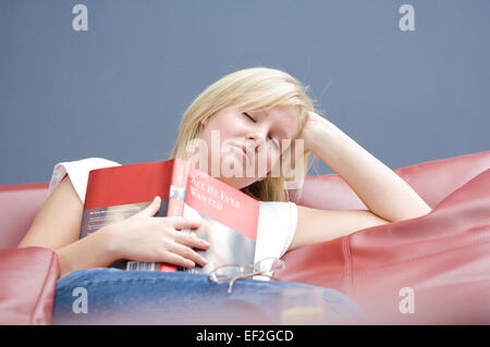 Woman resting on a modern leather sofa Stock Photo