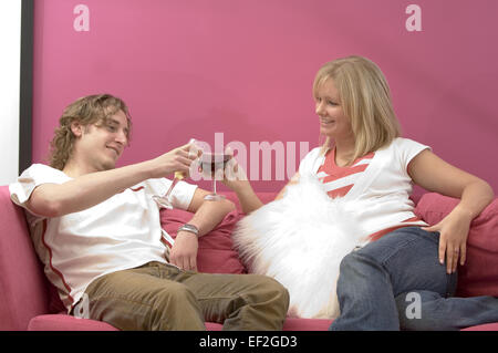 Couple relaxing on a sofa and toasting to each other Stock Photo