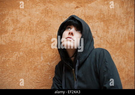 Dark young woman sad standing near urban wall portrait Stock Photo