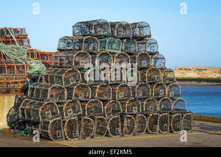 Lobster or crab pots stacked on the quayside on the west side of Whitby Harbour North Yorkshire UK Stock Photo