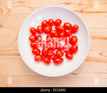 Pomodorino baby Plum Tomatoes for cooking or snacking in a white bowl Stock Photo