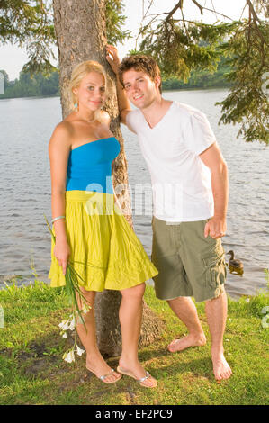 Couple standing by the water's edge Stock Photo