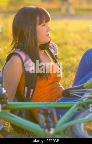 Cyclist sitting on grass Stock Photo