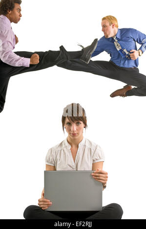 Two men fighting while woman works on laptop Stock Photo