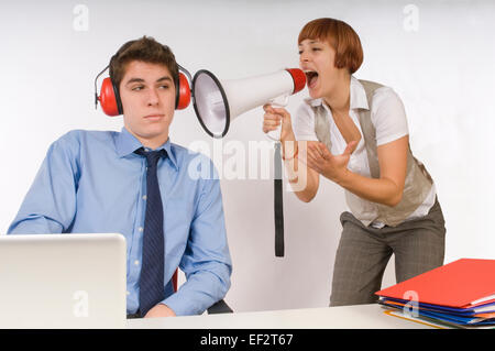 Woman using a bullhorn to yell at daydreaming businessman Stock Photo
