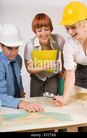 Three business people looking at a map Stock Photo
