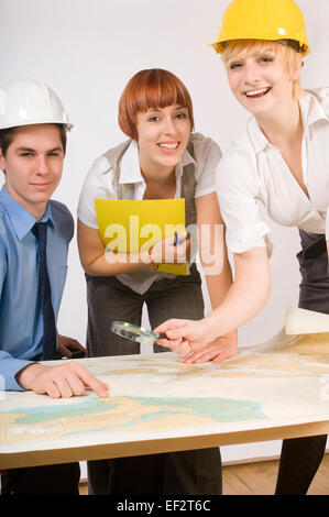 Three businesspeople looking at a map Stock Photo