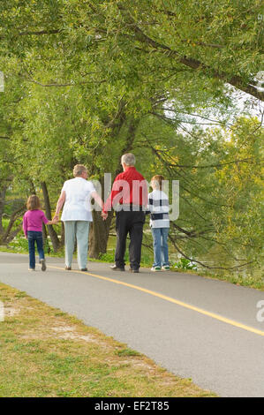 Grandparents and grandchildren walking on park path Stock Photo