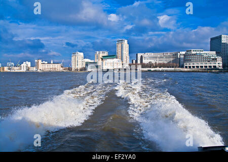 The wake from a Thames Clipper catamaran as it travels at high speed over the river after leaving Canary Wharf pier, London Stock Photo